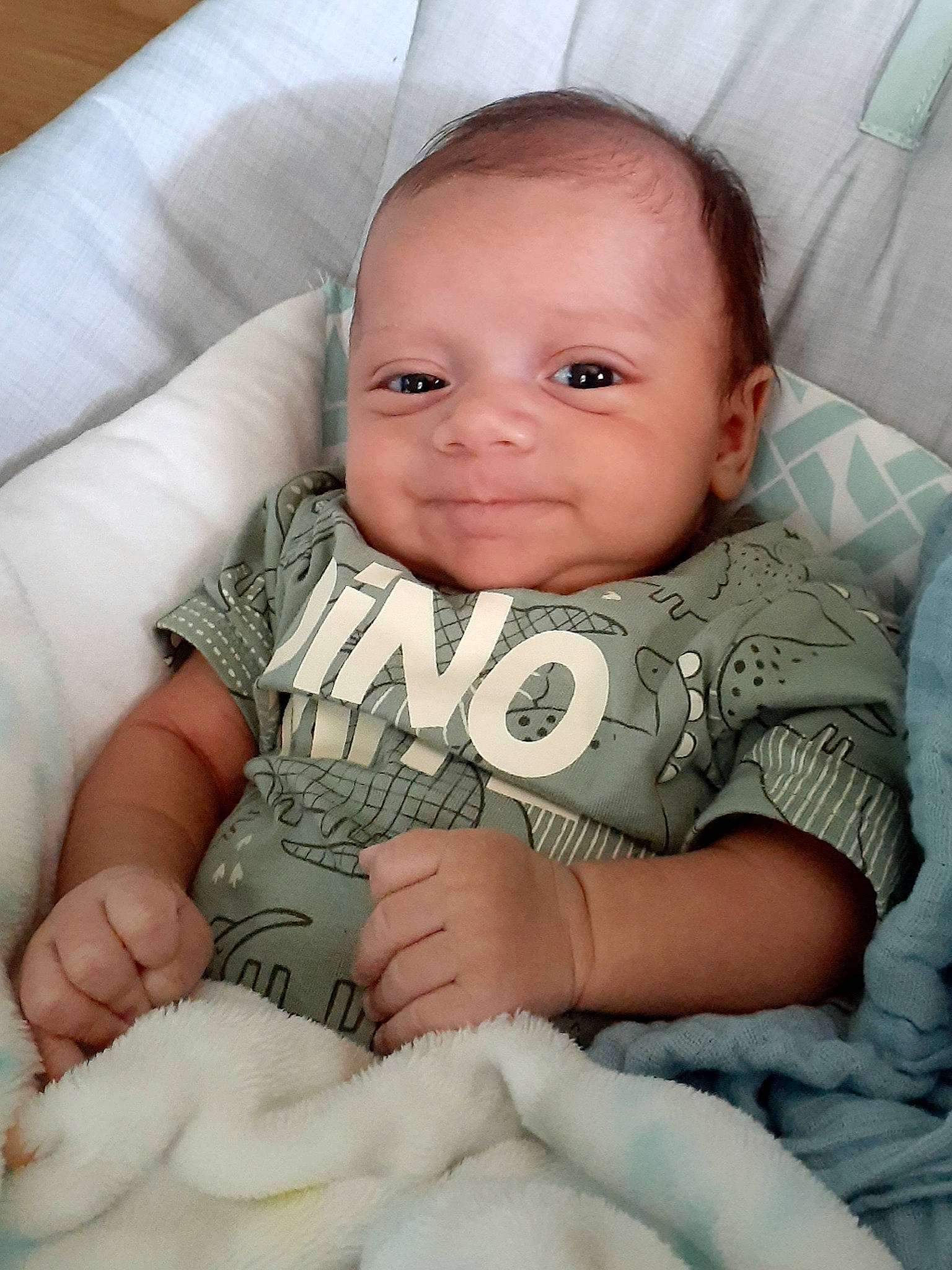 Kingsley is registered to the contest to win money with this photo: arm, baby, baby_toddler_clothing, cheek, chin, comfort, eye, eyebrow, face, facial_expression, iris, lip, mouth, nose, organ, person, skin, sleeve, smile, textile