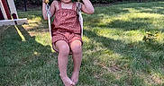 Amalia is registered to the contest to win money with this photo: child, swing, grass, outdoor, playground, smile, curly_hair, summer, sunlight, greenery, happy, person, play, leisure, nature, fence, tree, clothing, fun, daytime