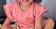 Amalia joined the competition — help win amazing prizes! casual_clothing, child, cross_legged, curly_hair, cute, face, feet, happy, home, indoor, light, person, pink_shirt, playful, portrait, quilted_surface, shorts, sitting, smiling, young