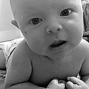 Zoey is registered to the contest to win money with this photo: baby, infant, close_up, black_and_white, face, eyes, hands, blanket, indoor, curious, skin, head, expression, child, toddler, lying_down, portrait, young, cute, person