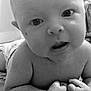 baby, infant, close_up, black_and_white, face, eyes, hands, blanket, indoor, curious, skin, head, expression, child, toddler, lying_down, portrait, young, cute, person