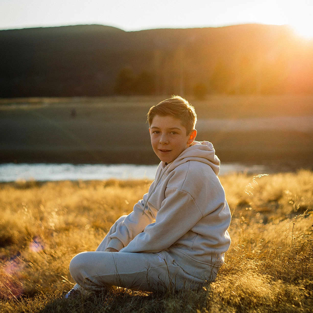 Enzo participe au concours pour gagner de l'argent avec cette photo : boy, child, clothing, face, flare, grass, happy, head, light, male, nature, outdoors, pants, person, photography, plant, portrait, sitting, sky, smile