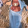 baby, pacifier, blue_towel, swaddled, newborn, infant, face, hood, striped, fabric, mattress, patterned, soft_texture, lying_down, skin, hand, cute, indoor, sleepwear, blanket