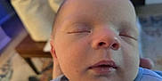 Ayden is registered to the contest to win money with this photo: baby, sleeping, close_up, face, infant, child, peaceful, indoor, portrait, soft_lighting, cozy, clothing, person, human, head, peace, young, newborn, rest, relaxation