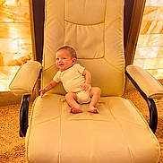 Bailey joined the competition — help win amazing prizes! baby, infant, chair, beige, onesie, carpet, stone_wall, indoor, furniture, person, seat, small, cute, child, young, office_chair, floor, relaxed, happy, cozy