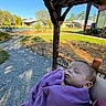 Bailey is registered to the contest to win money with this photo: baby, blanket, sleeping, outdoor, garden, path, wooden_structure, building, grass, trees, sunlight, peaceful, infant, portrait, nature, daytime, relaxation, purple_blanket, bench, face