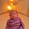 baby, newborn, sleeping, wrapped, purple_blanket, closeup, indoor, infant, peaceful, soft_lighting, portrait, young_child, cozy, warm_colors, toddler, child, cute, adorable, person, blanket