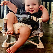 Brooks joined the competition — help win amazing prizes! baby, toddler, child, smiling, tongue_out, diaper, chair, wooden_floor, indoor, casual_clothing, playful, cute, happy, person, infant, seatbelt, small_chair, relaxed, hands, feet