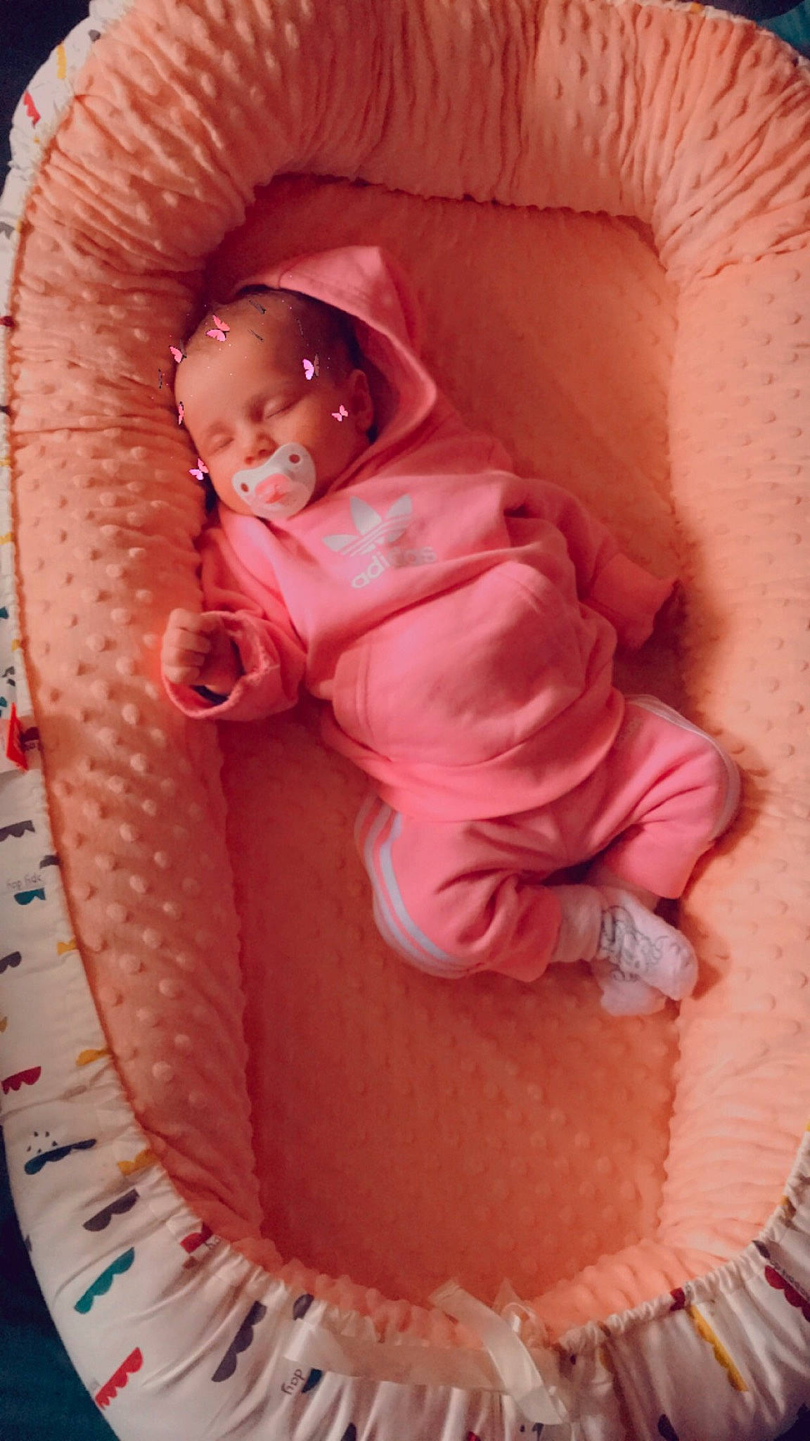 Adélina participe au concours pour gagner de l'argent avec cette photo : baby, baby_products, baby_safety, baby_sleeping, baby_toddler_clothing, baby_toys, cheek, child, comfort, infant_bed, linens, magenta, mouth, orange, peach, person, pink, sitting, skin, sleeve