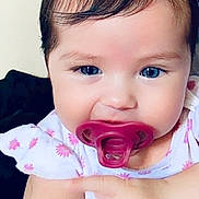Ameliyah is registered to the contest to win money with this photo: baby, child, pacifier, blue_eyes, pigtails, hair_ties, cute, infant, holding_hand, floral_clothing, closeup, portrait, adorable, skin, face, smiling, indoors, person, young_child, toddler
