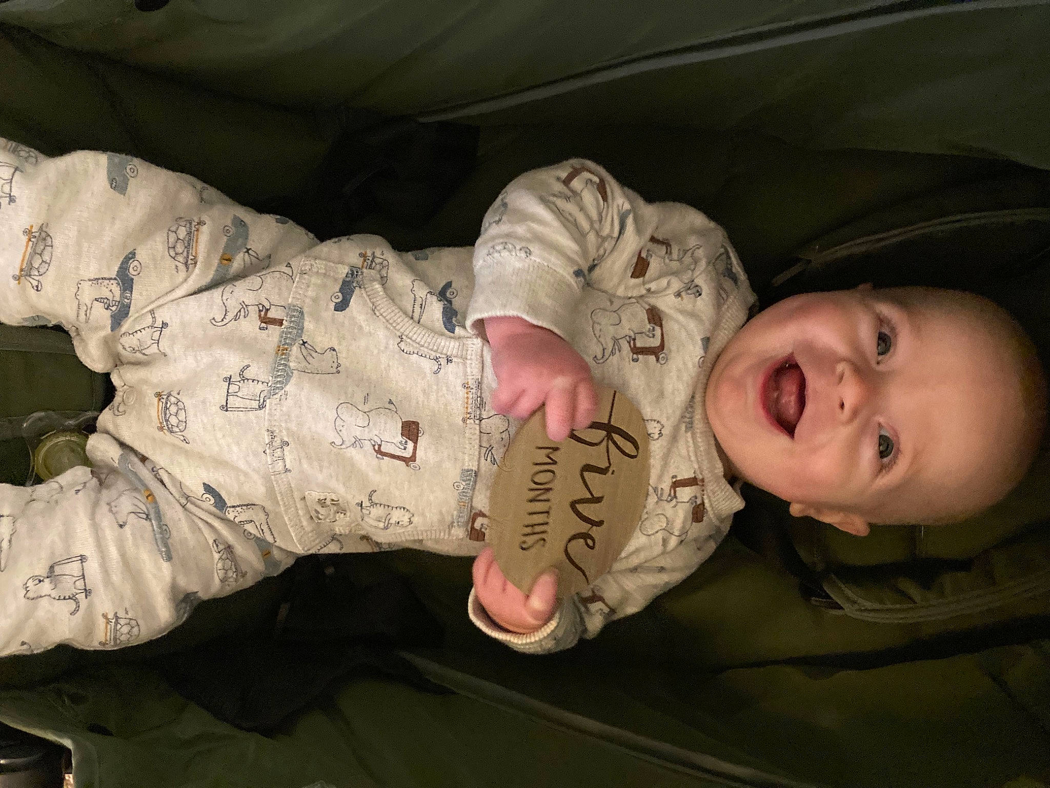 Neil is registered to the contest to win money with this photo: baby, baby_toddler_clothing, camouflage, cheek, child, comfort, eye, flash_photography, foot, fun, gesture, happy, human_body, military_camouflage, mouth, person, skin, sleeve, smile, thumb