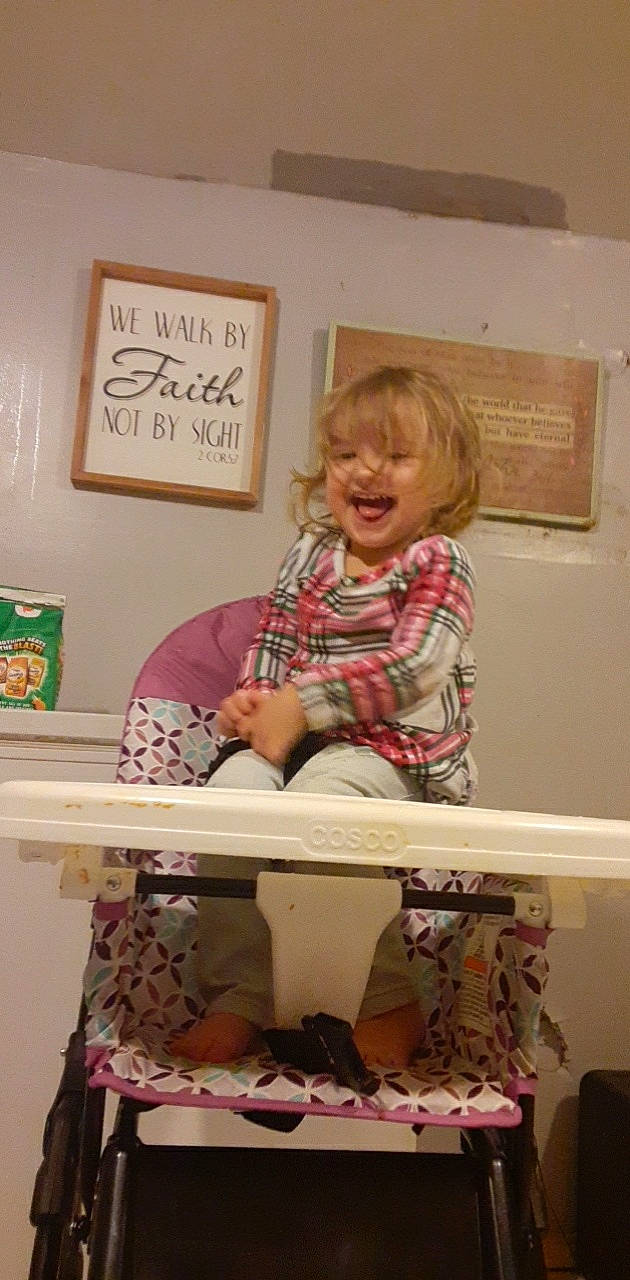 Amellia is registered to the contest to win money with this photo: art, child, creative_arts, drawer, handwriting, home_accessories, linens, pattern, person, picture_frame, plaid, play, room, sitting, sleeve, smile, t_shirt, toddler, visual_arts, wood