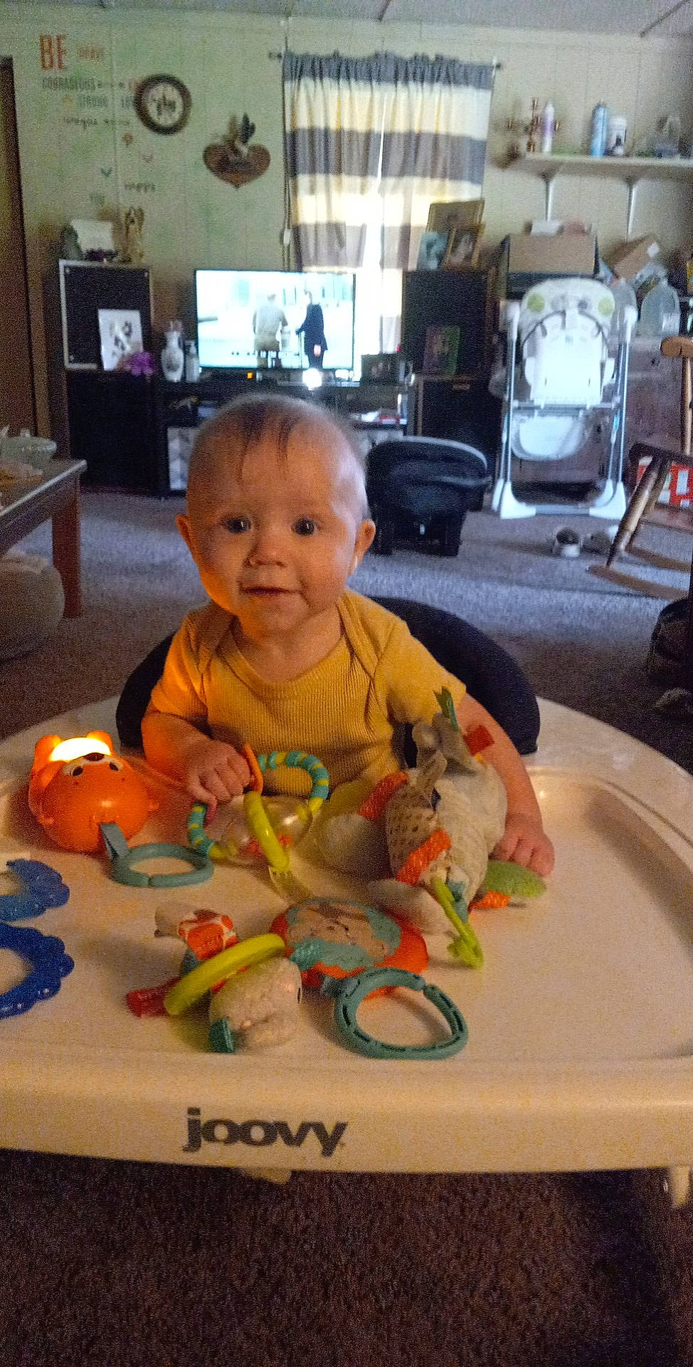 Braden joined the competition — help win amazing prizes! baby, baby_toys, chair, cheek, child, eye, flooring, fun, lamp, person, picture_frame, play, room, sitting, skin, smile, stuffed_toy, television, toddler, toy