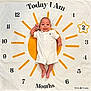 Kaya is registered to the contest to win money with this photo: baby, infant, smiling, white_clothing, milestone_blanket, age_marker, months, clock_design, yellow, white_background, star_shape, cute, child, portrait, laying_down, happy, indoors, soft_texture, newborn, celebration