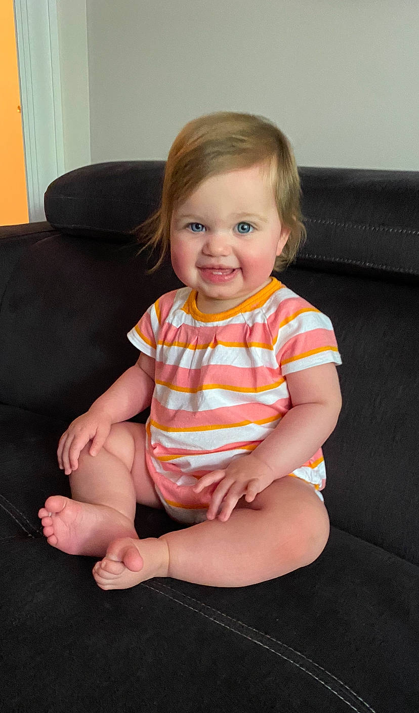 Roxanne joined the competition — help win amazing prizes! baby_toddler_clothing, cheek, child, comfort, eye, finger, floor, flooring, fun, happy, human_leg, joy, knee, person, sitting, skin, sleeve, smile, standing, t_shirt