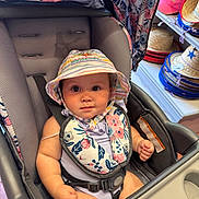Kehlani joined the competition — help win amazing prizes! accessory, baby, bib, child, clothing, colorful, cute, expression, face, floral_pattern, hat, indoors, infant, person, portrait, seatbelt, shopping, sitting, store, stroller