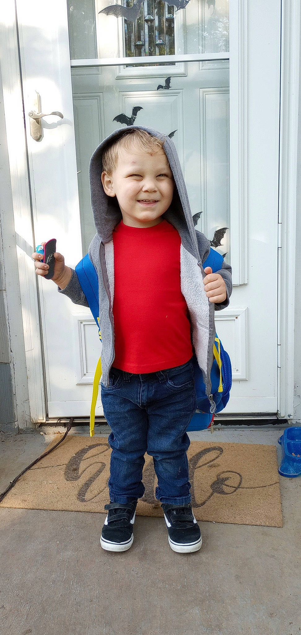 Franklin is registered to the contest to win money with this photo: bag, blue, boot, child, costume, denim, door, electric_blue, flooring, fun, gesture, happy, joy, person, personal_protective_equipment, sleeve, smile, standing, thumb, toddler