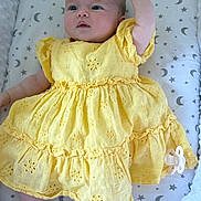 Konnie is registered to the contest to win money with this photo: baby, yellow_dress, infant, lying_down, raised_arm, pacifier, patterned_bedding, stars, moons, soft_texture, cute, child, portrait, sleeping_area, adorable, clothing, fabric, newborn, resting, indoor
