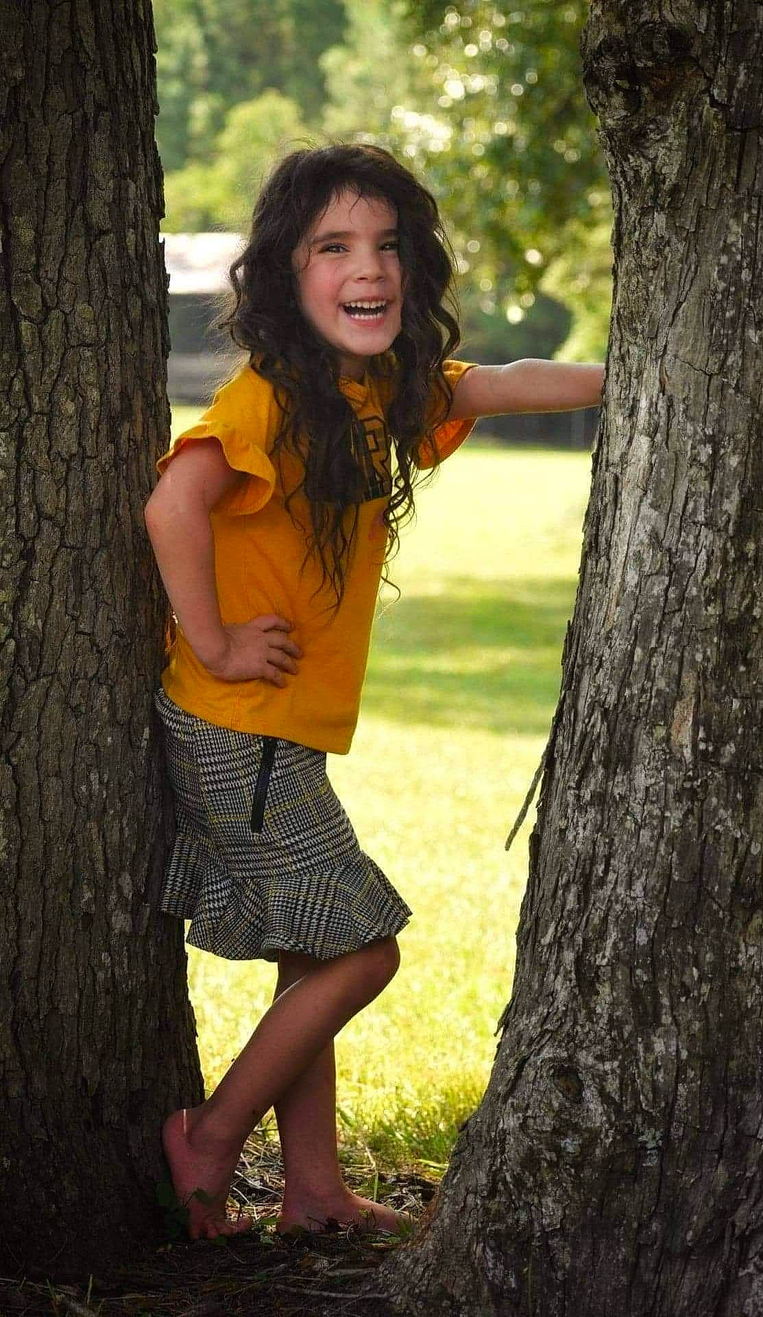 Felicity is registered to the contest to win money with this photo: black_hair, botany, branch, clothing, flash_photography, grass, hairstyle, happy, joy, knee, leaf, people_in_nature, person, plant, smile, standing, thigh, tree, trunk, waist