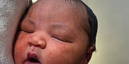 Khyla is registered to the contest to win money with this photo: baby, newborn, sleeping, infant, pink_clothing, person, closeup, face, skin, cute, peaceful, resting, human, child, portrait, soft, warm_light, indoors, tender, holding