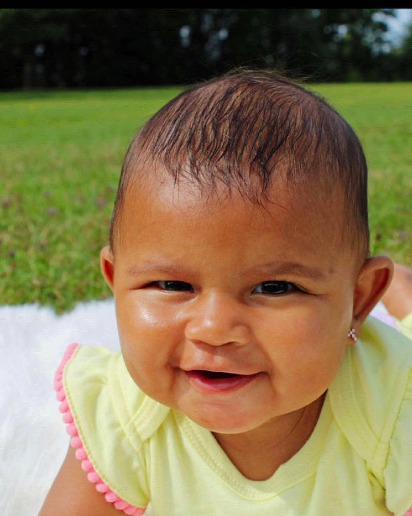 Arya joined the competition — help win amazing prizes! arm, baby_toddler_clothing, cheek, ear, eye, eyebrow, eyelash, finger, gesture, grass, happy, human_body, iris, lip, mouth, neck, nose, person, skin, smile