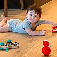 David joined the competition — help win amazing prizes! baby, child, toy, floor, wooden_floor, indoor, crawling, curious, cute, infant, playtime, person, blue_outfit, wood, furniture_leg, small_toy, red_toy, zebra_toy, bright_colors, young_child