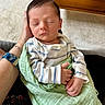 baby, newborn, sleeping, hand, blanket, striped_clothing, indoor, person, watch, comfort, resting, peaceful, closeup, skin, infant, care, parent, wrapped, toddler, cute