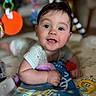 David is registered to the contest to win money with this photo: baby, infant, child, tummy_time, toy, colorful, blue_eyes, smiling, indoor, playtime, blanket, cute, happy, person, young_child, soft_focus, close_up, clothing, hand, face