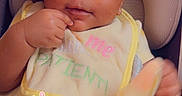 Cimani joined the competition — help win amazing prizes! baby, infant, child, headband, bib, yellow_clothing, seat, cushion, cute, skin, hand, cloth, portrait, looking, indoor, adorable, pink_heart, text_overlay, face, eyes
