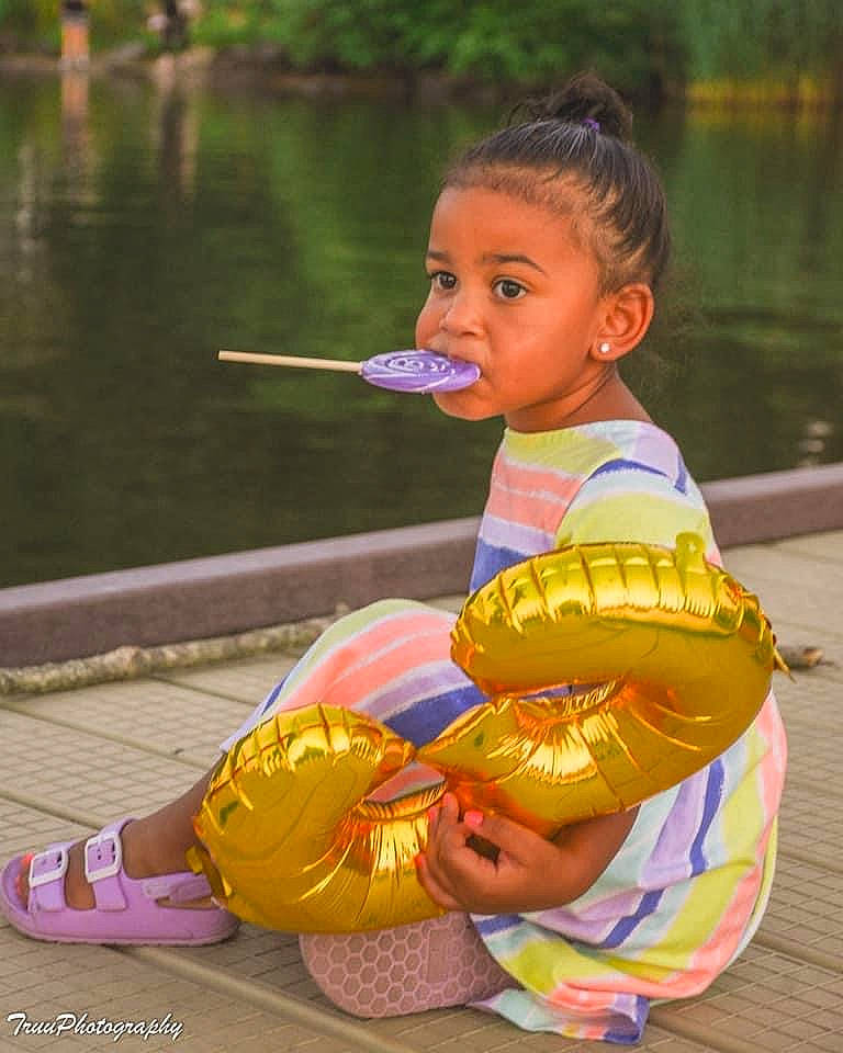 Khloe joined the competition — help win amazing prizes! boats_and_boating_equipment_and_supplies, child, face, fun, grass, happy, lake, leisure, people_in_nature, person, personal_protective_equipment, play, recreation, sitting, skin, temple, toddler, tourism, vacation, water