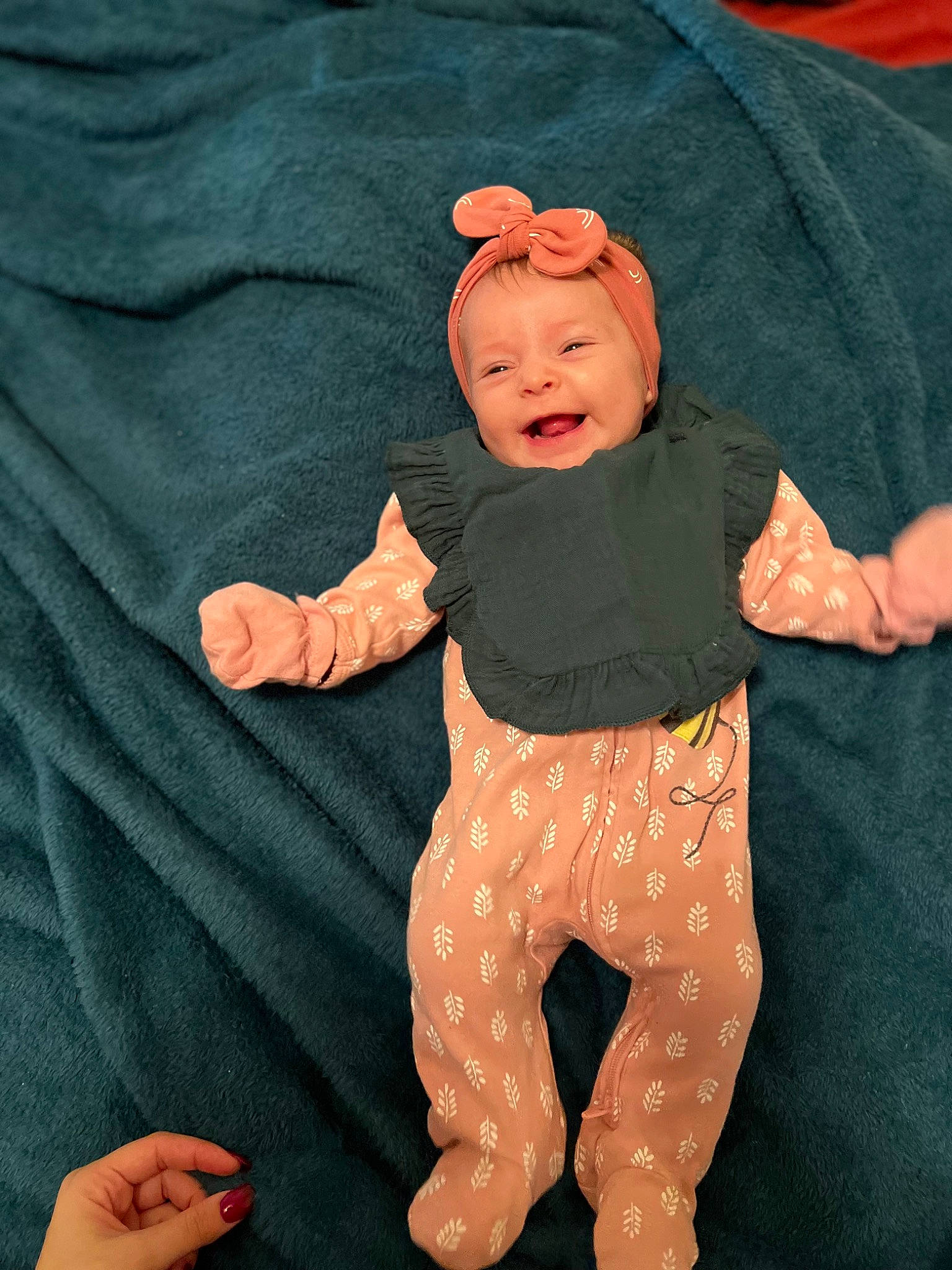 Sloan is registered to the contest to win money with this photo: baby, baby_products, baby_toddler_clothing, child, comfort, finger, gesture, hand, happy, hat, headwear, linens, nail, pattern, peach, person, sleeve, t_shirt, textile, thigh