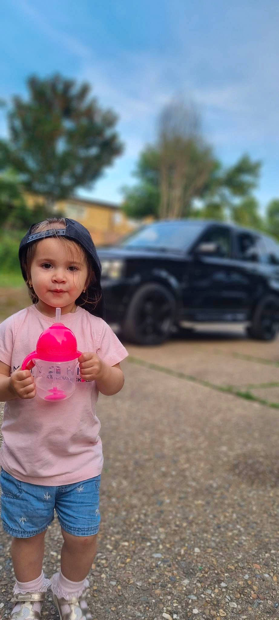 Clara joined the competition — help win amazing prizes! asphalt, automotive_design, automotive_tire, car, grass, happy, headwear, landscape, leisure, motor_vehicle, person, personal_luxury_car, recreation, rim, rolling, tire, toddler, tree, vehicle, vehicle_door