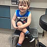 Greyson joined the competition — help win amazing prizes! child, boy, smiling, sitting, crossed_legs, sneakers, blue_shirt, shorts, indoor, stool, carpet, cabinet, medical_office, furniture, person, happy, young, casual, portrait, playful