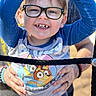 Greyson is registered to the contest to win money with this photo: child, glasses, smile, happy, outdoor, hands, person, blue_sleeves, shirt, cartoon, playground, rope, holding, casual_clothing, daylight, cute, young_child, portrait, joyful, fun