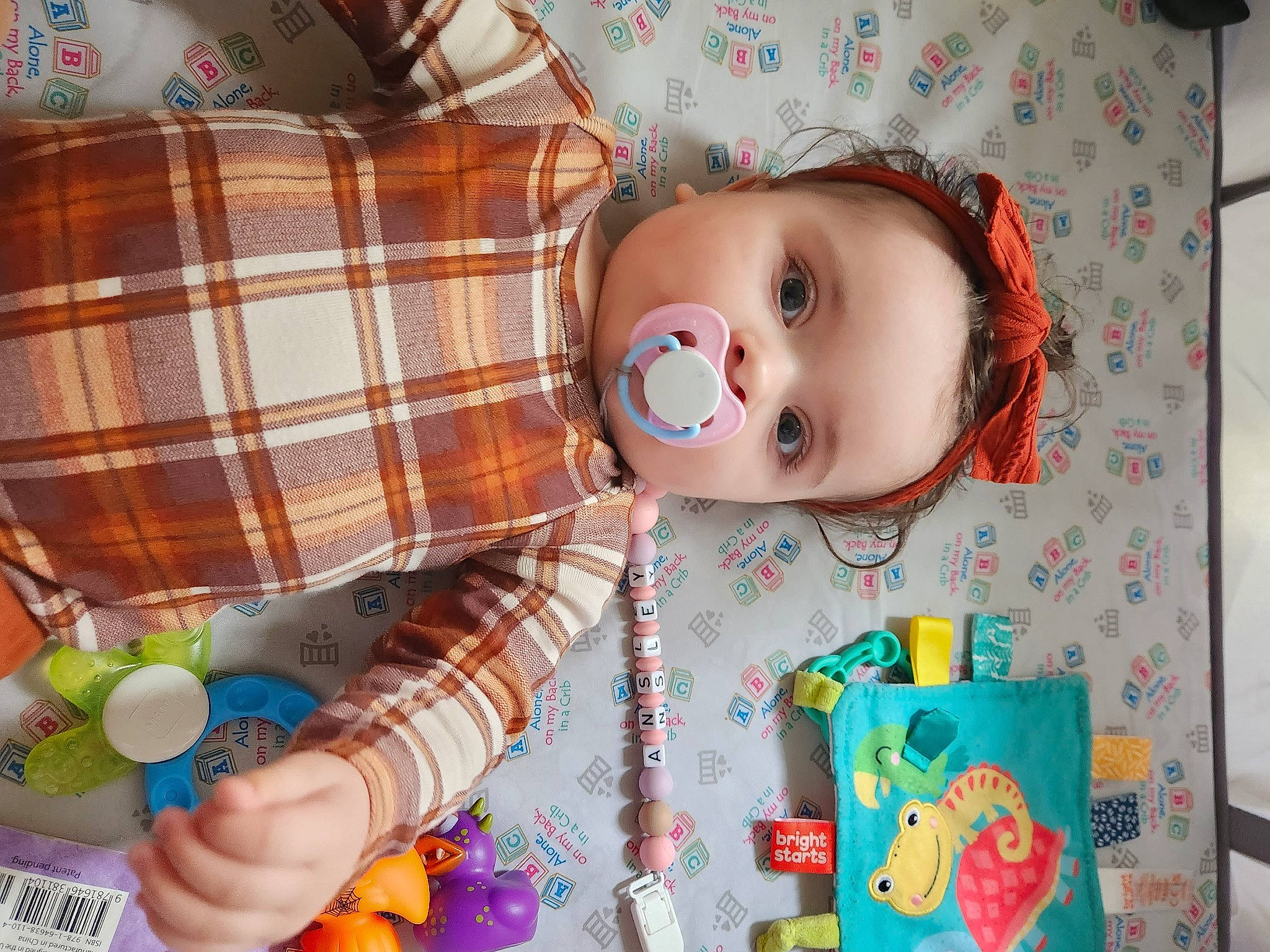 Ansley is registered to the contest to win money with this photo: baby, baby_products, baby_toddler_clothing, baby_toys, cheek, child, doll, event, eyelash, orange, pattern, person, plaid, plastic, product, room, shelf, tartan, textile, toddler