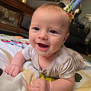 Malachi joined the competition — help win amazing prizes! baby, child, infant, smiling, happy, portrait, face, eyes, open_mouth, sitting, lying_down, play_mat, blanket, onesie, home, indoor, bouncer, furniture, close_up, photography