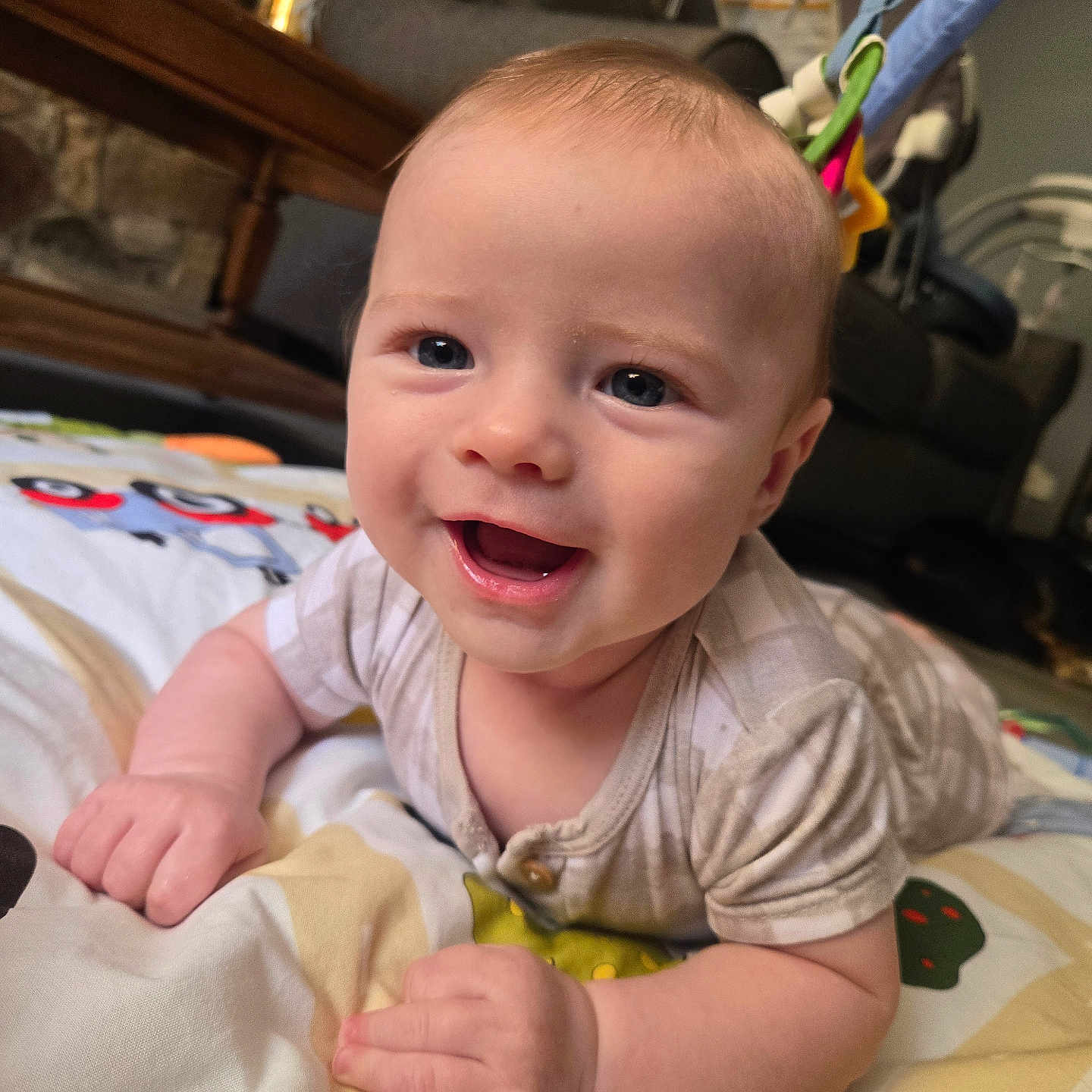 Malachi joined the competition — help win amazing prizes! baby, child, infant, smiling, happy, portrait, face, eyes, open_mouth, sitting, lying_down, play_mat, blanket, onesie, home, indoor, bouncer, furniture, close_up, photography