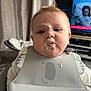 Louie joined the competition — help win amazing prizes! baby, bib, food, messy, face, child, indoor, curtain, television, blond_hair, chubby_cheeks, feeding, highchair, clothing, expressionless, portrait, young_child, candid, mess, home