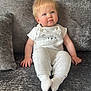 Louie is registered to the contest to win money with this photo: baby, child, infant, sitting, sofa, couch, gray, clothing, overalls, white_socks, blonde_hair, blue_eyes, cute, plush, indoor, portrait, young_child, smiling, happy, cozy