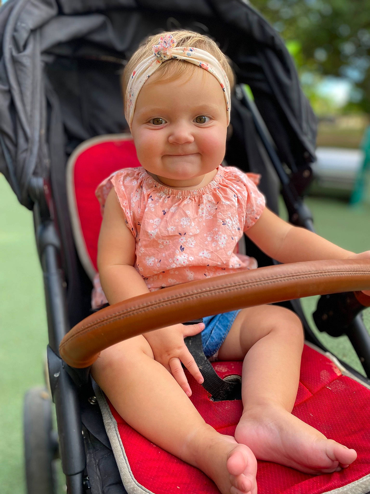 Mila a rejoint le concours — aidez-le/la à gagner de superbes lots ! baby_carriage, baby_toddler_clothing, eye, fun, grass, happy, human_leg, joy, lap, leg, leisure, person, photograph, pink, recreation, red, shorts, skin, smile, summer