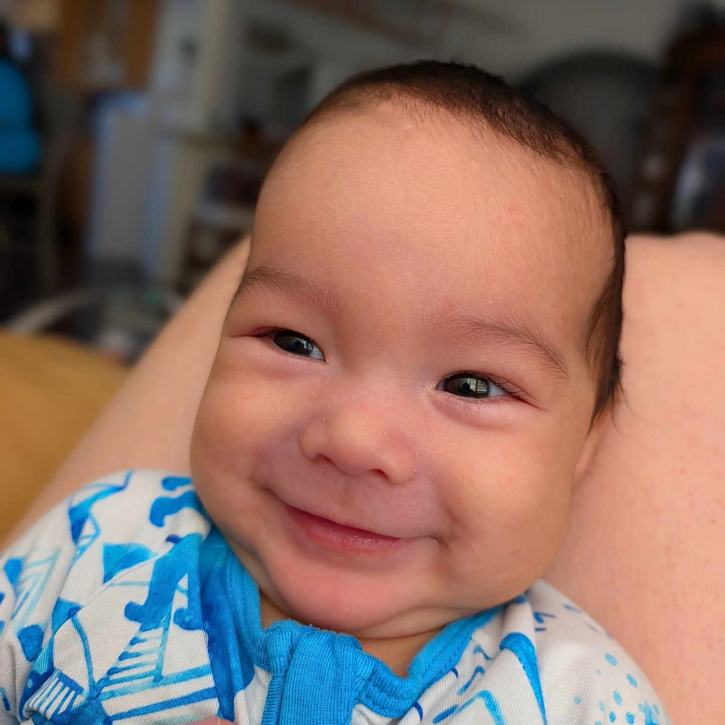Julian is registered to the contest to win money with this photo: baby, smile, face, infant, clothing, onesie, blue, white, hand, skin, indoor, portrait, cute, happy, child, newborn, person, expression, closeup, young