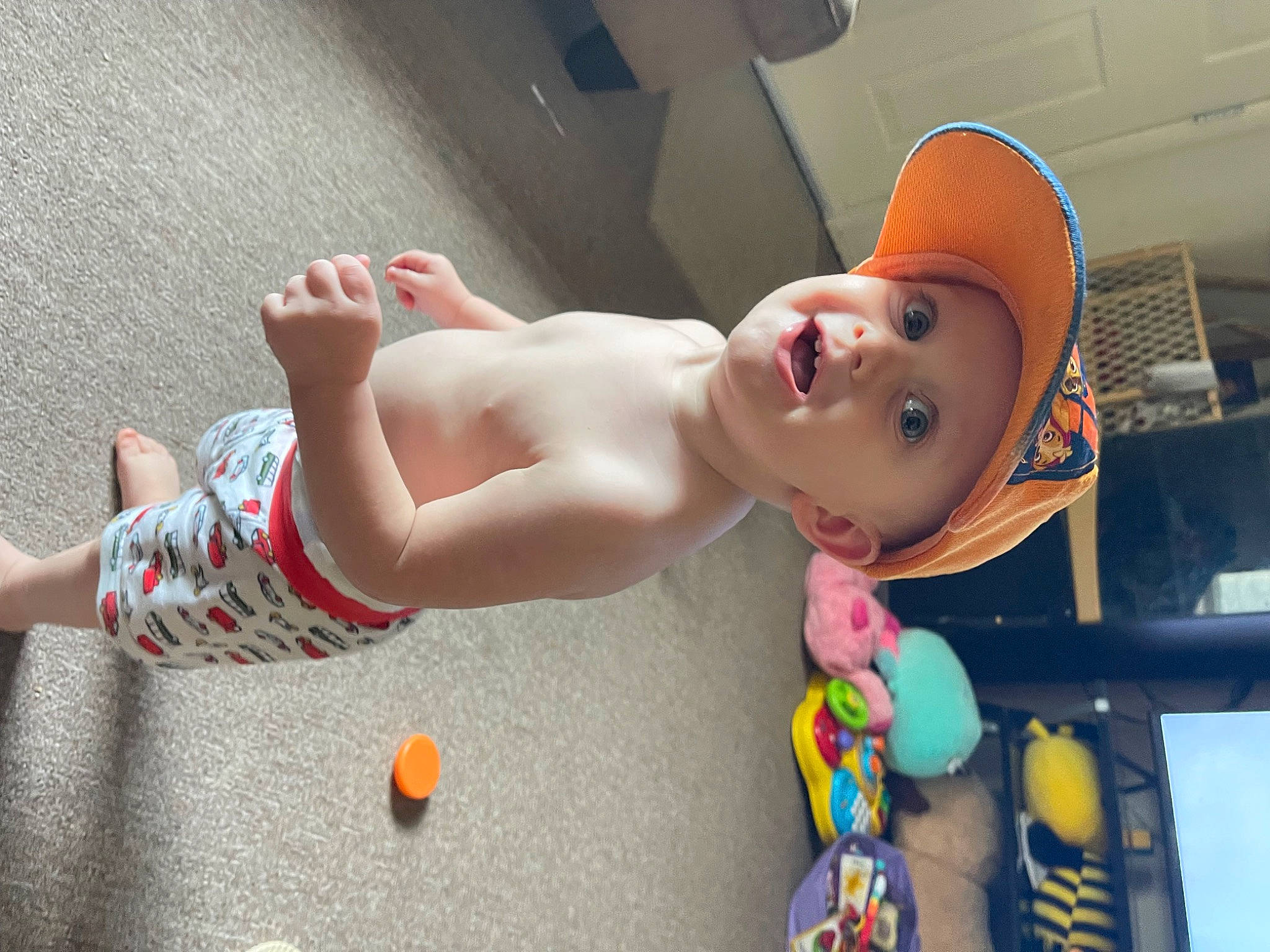 George is registered to the contest to win money with this photo: baby, barechested, cap, chest, child, elbow, entertainment, event, eyewear, foot, fun, hat, headwear, human_leg, leisure, muscle, person, sun_hat, surprise, thigh