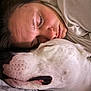person, dog, sleeping, close_up, cuddle, bed, blanket, face, rest, comfort, pet, animal, white_dog, skin, expression, relaxation, indoor, cozy, companion, affection