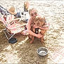 Staxx is registered to the contest to win money with this photo: beach, sand, woman, dog, hug, sunglasses, tattoo, beach_chair, hat, water_bowl, outdoor, sunny, relaxation, summer, pet, leash, casual, smile, vacation, friendship