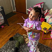 Malaya joined the competition — help win amazing prizes! child, toddler, girl, smile, pajamas, braids, toys, plush_toy, playroom, hardwood_floor, rug, standing, indoor, happy, shirt, bracelet, door, stroller, colorful_toy, bedroom