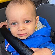 Aaron participe au concours pour gagner de l'argent avec cette photo : toddler, child, blue_jacket, face, hand, stroller, seat, curious, closeup, indoor, person, clothing, skin, eyes, expression, young_child, portrait, baby, casual, grip