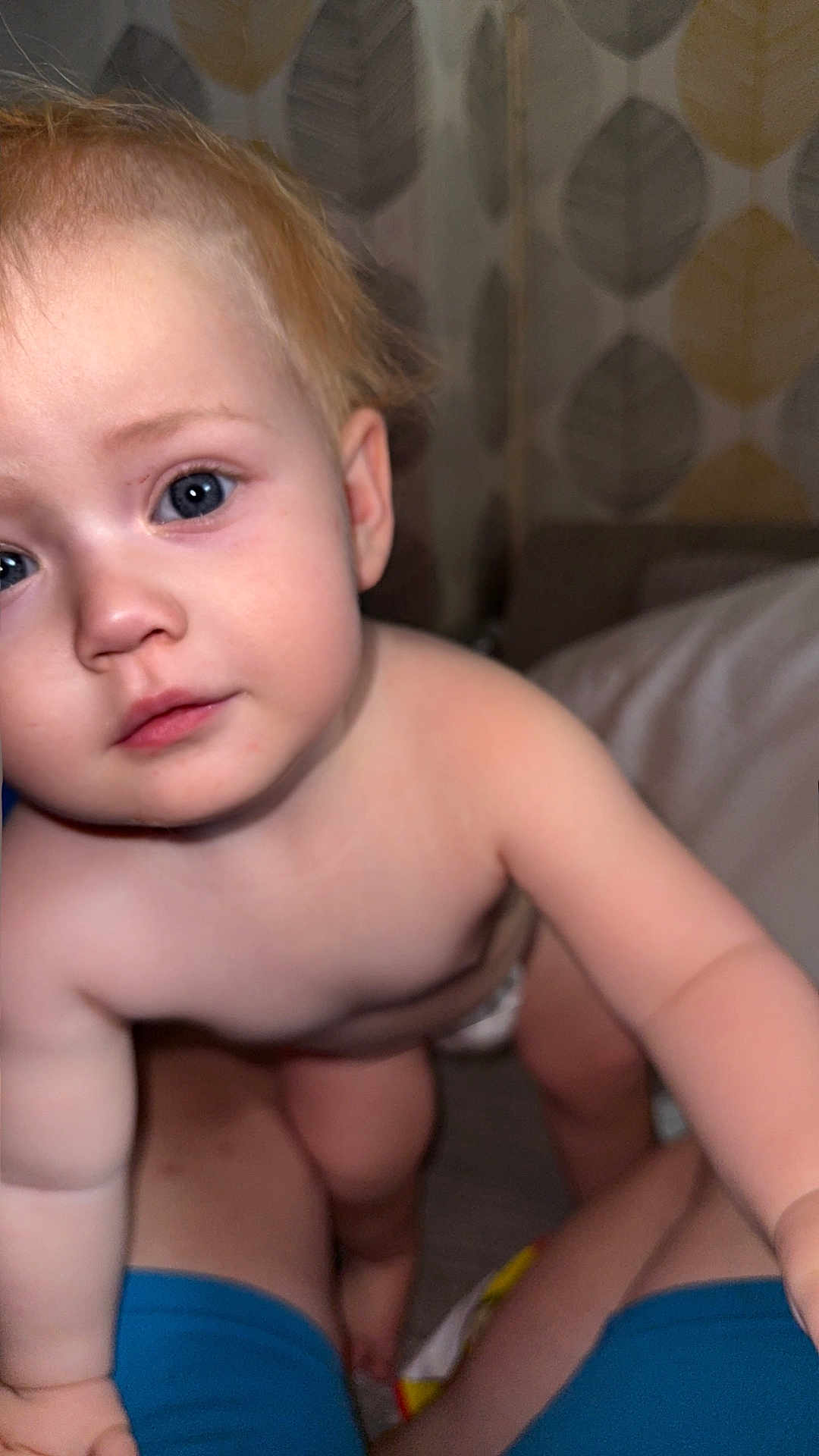 Amara-Rose joined the competition — help win amazing prizes! baby, child, infant, blue_eyes, blonde_hair, skin, face, curious, indoors, person, diaper, legs, arms, close_up, portrait, human, exploration, patterned_wallpaper, soft_light, candid