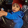 Jace is registered to the contest to win money with this photo: child, toddler, blue_hoodie, red_hat, steering_wheel, car_interior, night, curious, wide_eyes, portrait, clothing, hand, person, seat, car, dashboard, seatbelt, indoor, cute, expression