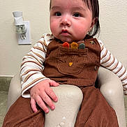 Paulo joined the competition — help win amazing prizes! baby, child, infant, overalls, striped_shirt, brown_clothing, baby_seat, indoor, wall, electrical_outlet, air_freshener, cute, hand, face, portrait, sitting, young_child, plush_seat, expression, person