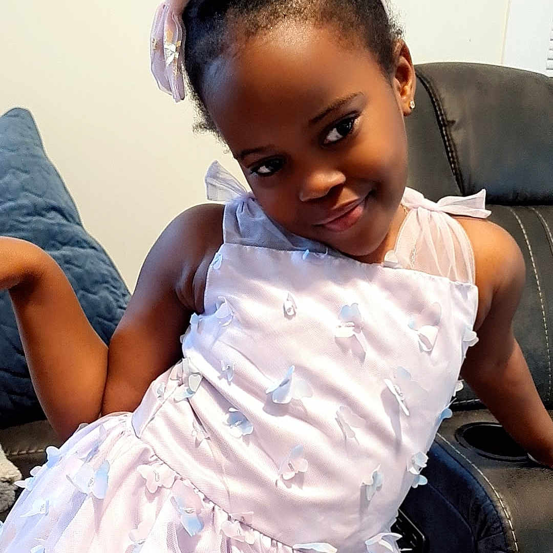 Abigail joined the competition — help win amazing prizes! baby, babylaughing, child, clothing, couch, cushion, dress, face, female, furniture, girl, hair, happy, head, person, photography, portrait, sitting, sleeve, smile